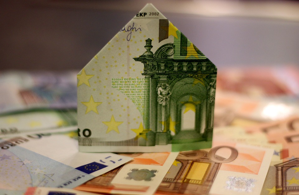Un billet de banque est plié pour prendre la forme d'une maison et représente la pierre papier SCPI